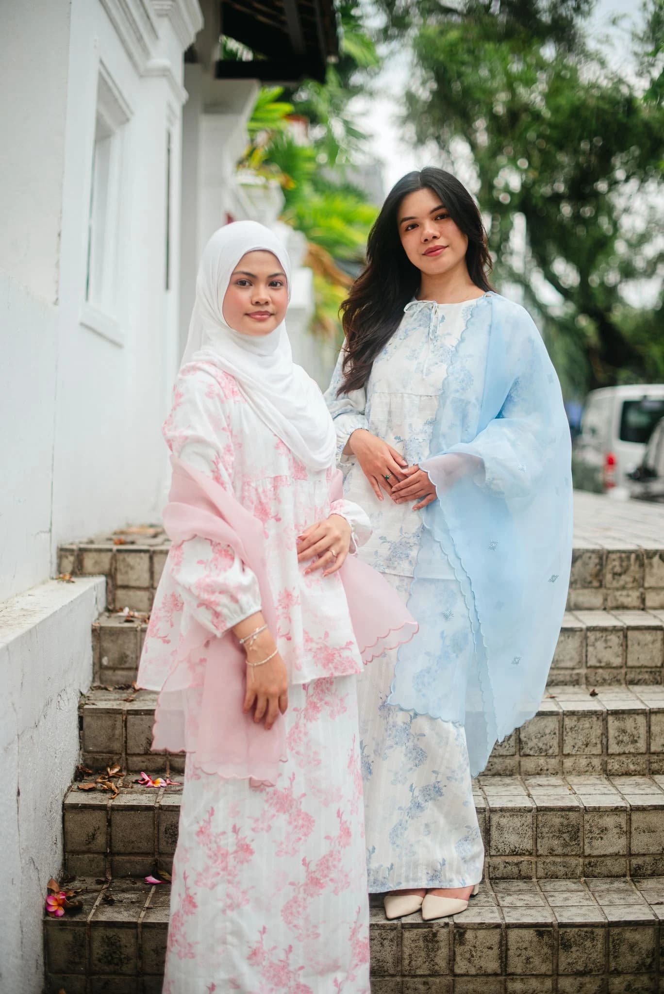 Two friends in Melrose Label sets on stone steps